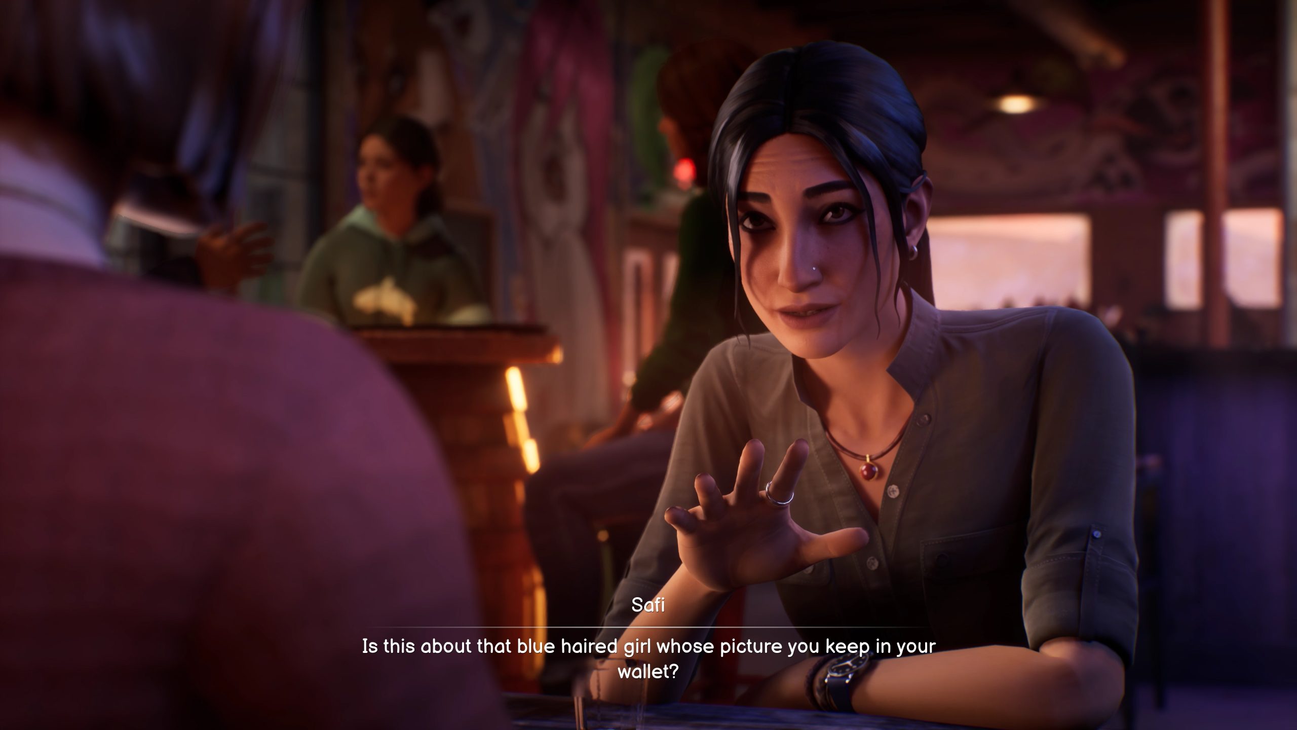 A screenshot from Life is Strange: Double Exposure. Safi, a girl with dark hair in a ponytail, is sitting across from some one. She says: "Is this about that blue-haired girl whose picture you keep in your waller?"