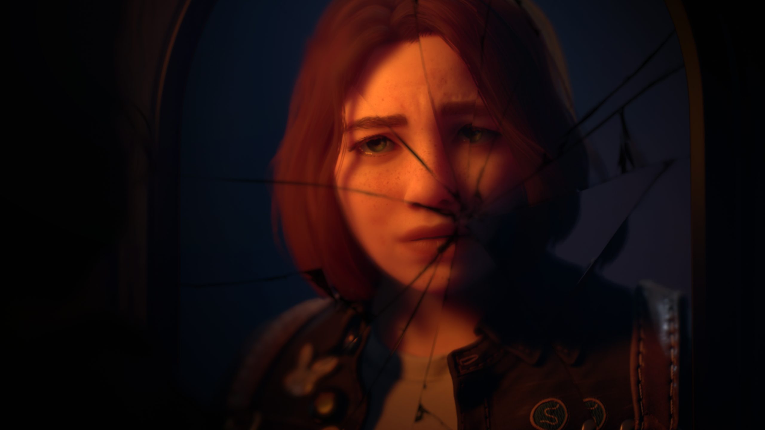 A screenshot from Lost Records: Bloom & Rage, provided to the press. It shows Starr - a teenage girl with chin-length brown hair, light eyes and lost of freckles - from the neck up as a reflection in a mirror that has been broken.